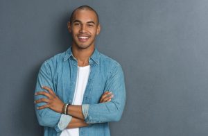 healthy man leaning against wall showing healthy smile
