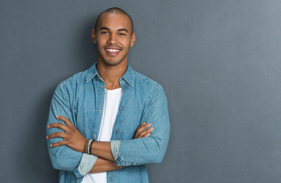 healthy man leaning against wall showing healthy smile