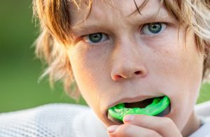 Young football player with green mouthguard