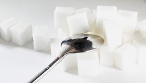 Pile of white sugar cubes and an upside-down silver spoon