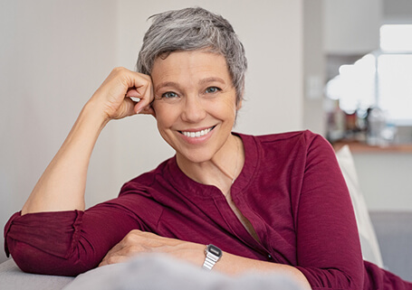 Woman Leaning On Hand Smiling