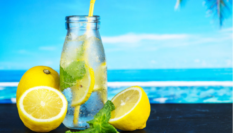 lemon juice infused water with the ocean in the background