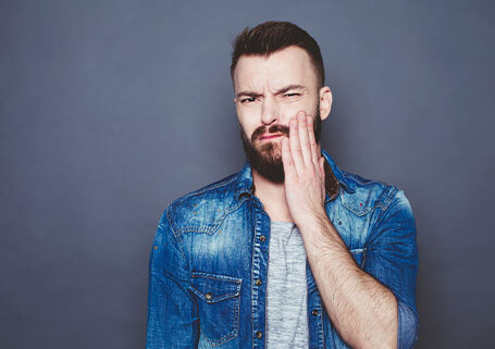 Man holding jaw in pain