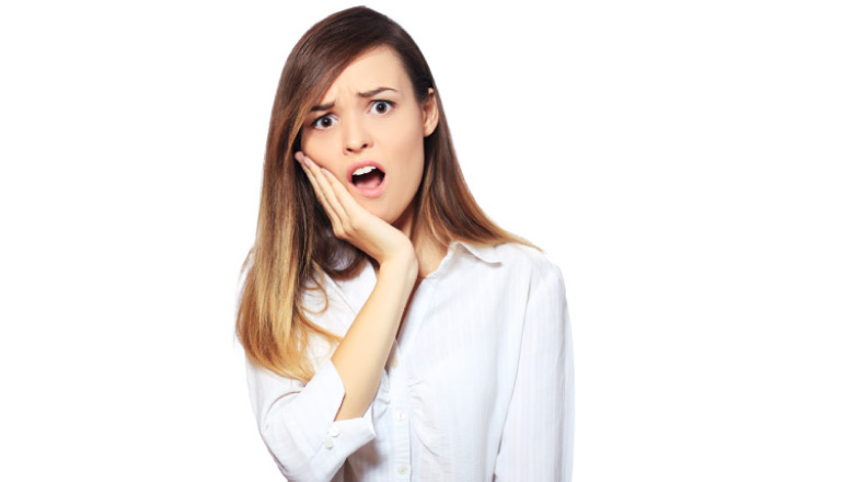 brown haired girl holding her jaw with a dental emergency