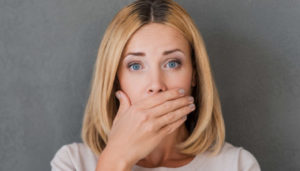 woman covers her mouth to hide gum disease