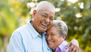 senior couple hug and smile after getting dentures