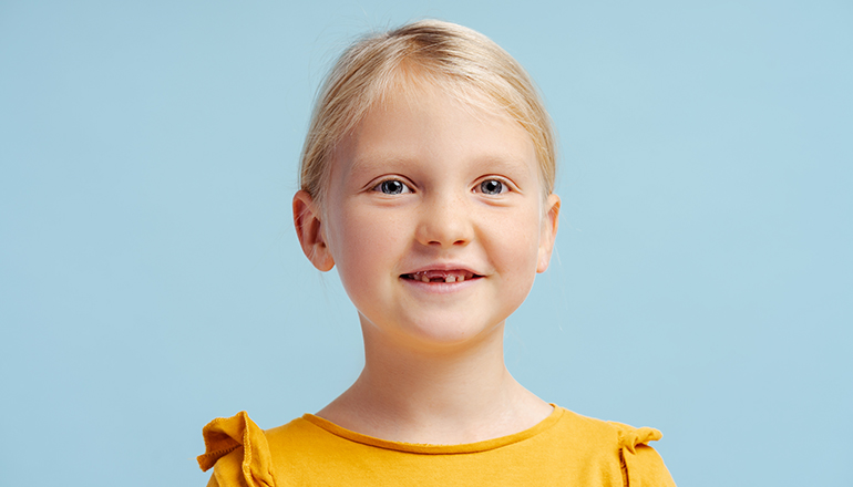 young girl with missing baby teeth